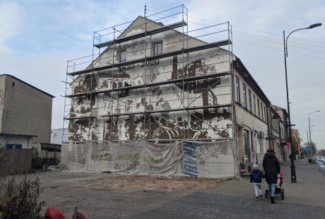 Na zdjęciu ściana budynku przy Placu Wolności 8, wraz rusztowaniem i powstającym muralem